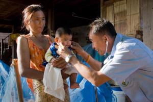Health care professional in Thailand helping a baby. 